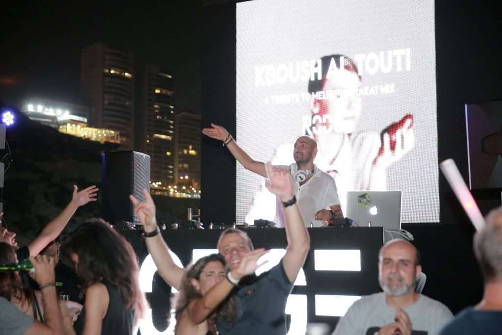 A DJ set on a summer night at Sporting Club Beach, the crowd dancing
