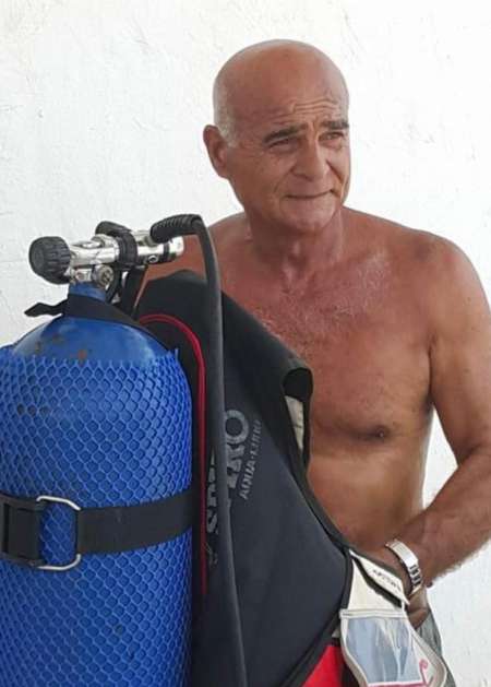 The diving instructor with scuba gear at Sporting Club Beach