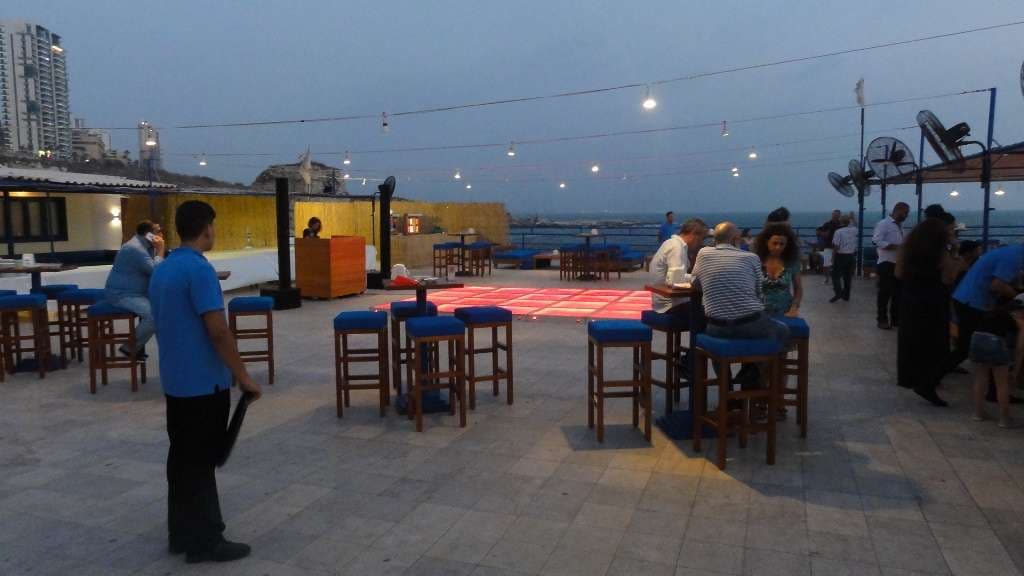 A dusk terrace event at Sporting Club Beach, high tables and a lit dancefloor