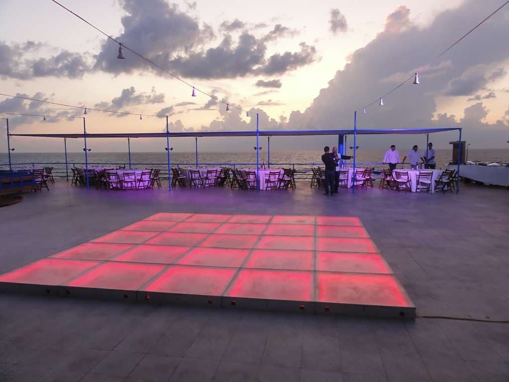 The terrace at Sporting Club Beach at sunset, set with a lit dancefloor for an event