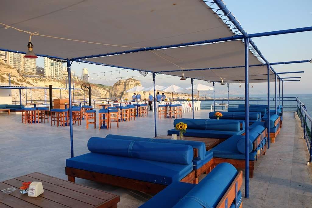 The event terrace at Sporting Club Beach, lounge seating and high tables by the sea