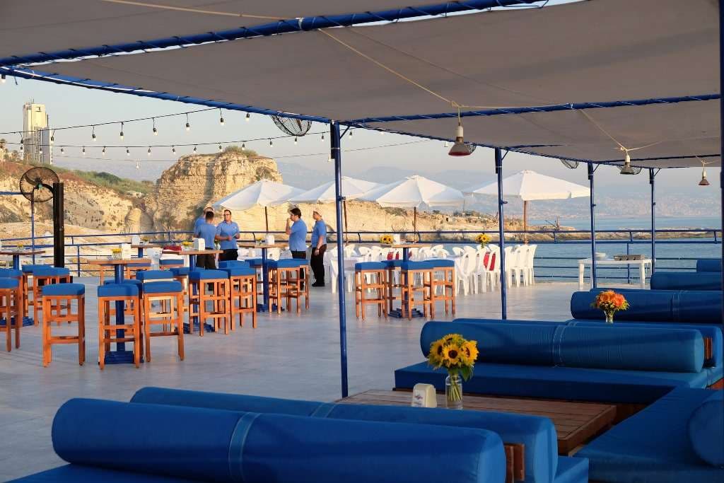 The event terrace at Sporting Club Beach set with sunflowers, staff preparing