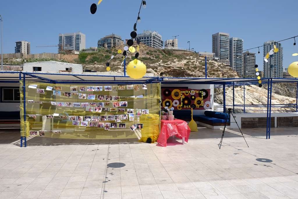 A daytime party set up on the terrace at Sporting Club Beach with bench seating