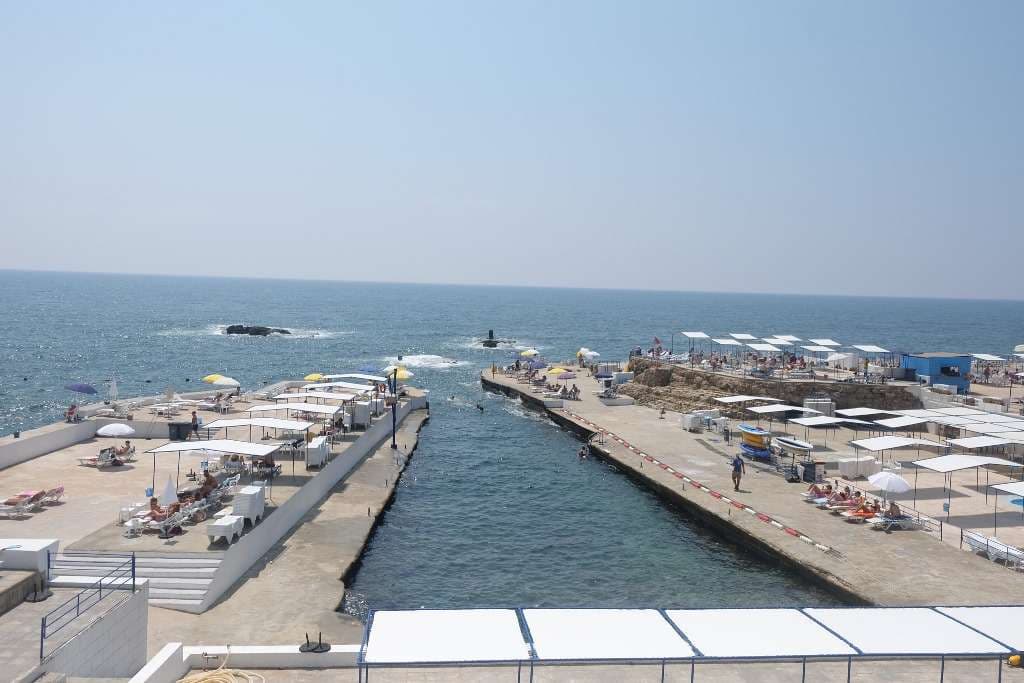Concrete bathing terraces reaching into the open sea along the rocky coast at Sporting Club Beach, Ras Beirut