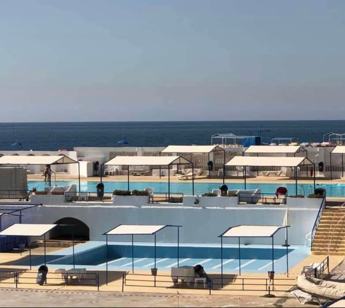 Shaded loungers and umbrellas on the pool deck at Sporting Club Beach