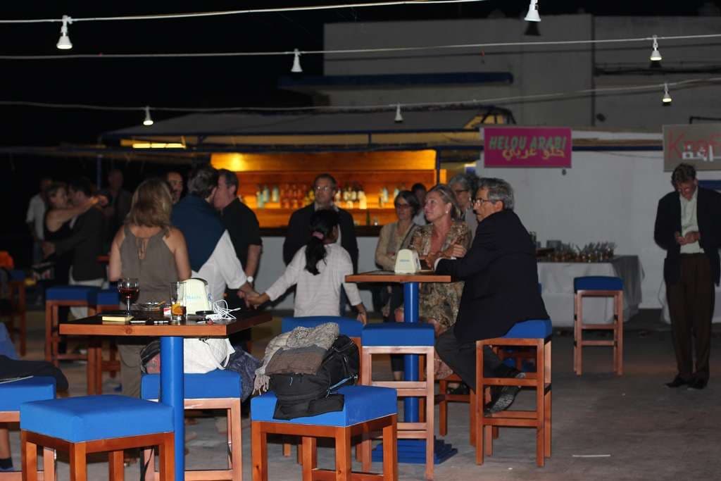 Guests gathered around the bar at an evening event at Sporting Club Beach, Ras Beirut