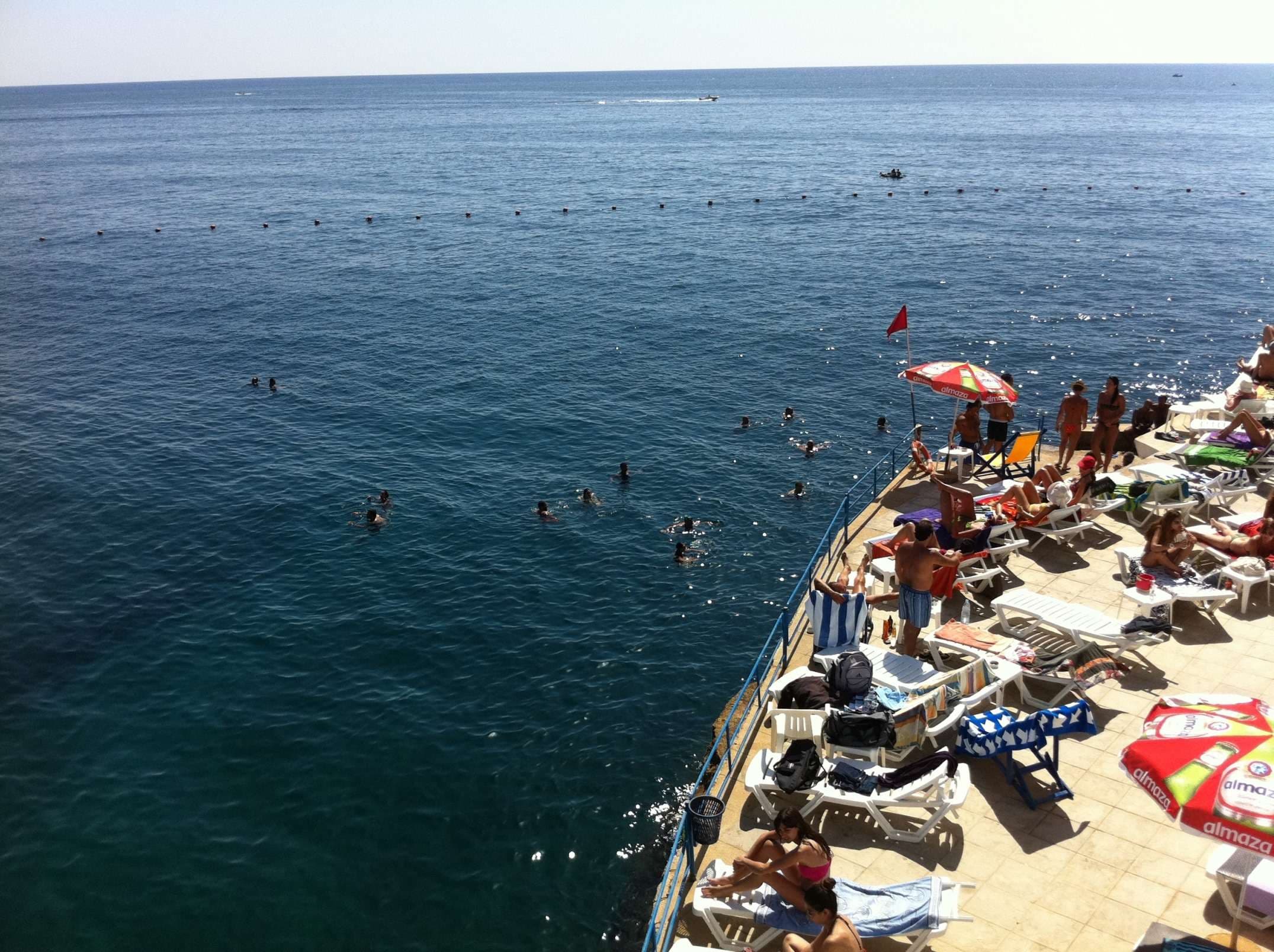 A busy summer day on the rocky terraces at Sporting Club Beach