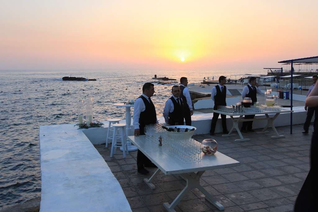 Staff setting up a seafront cocktail reception at sunset at Sporting Club Beach, Ras Beirut