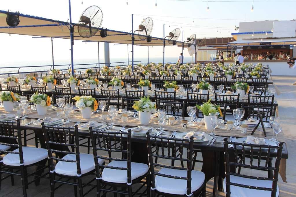 Long tables dressed with sunflowers under shade sails on the seafront terrace at Sporting Club Beach, Ras Beirut