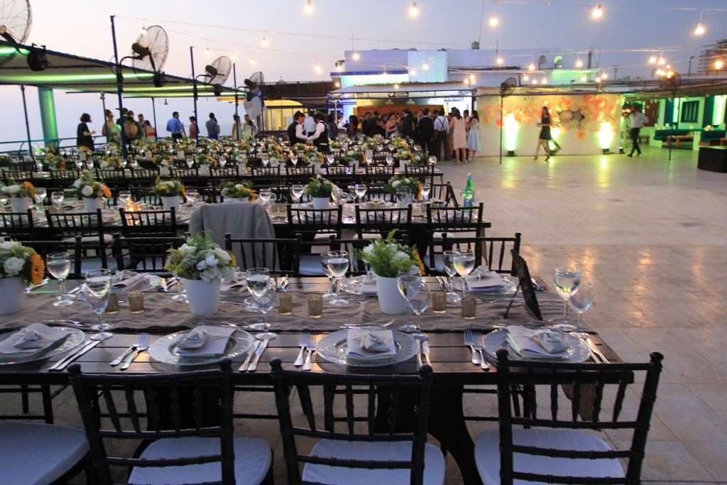 A wall of paper flowers lit by coloured uplights at an indoor event at Sporting Club Beach, Ras Beirut