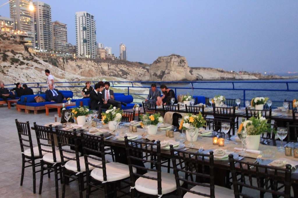 An evening event with set tables and an open dancefloor on the terrace at dusk at Sporting Club Beach, Ras Beirut