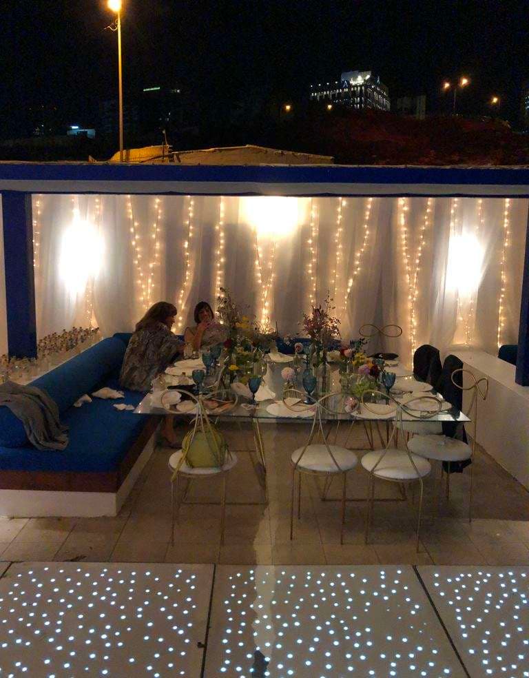 An intimate evening table dressed with flowers and fairy-light curtains on a terrace at Sporting Club Beach, Ras Beirut