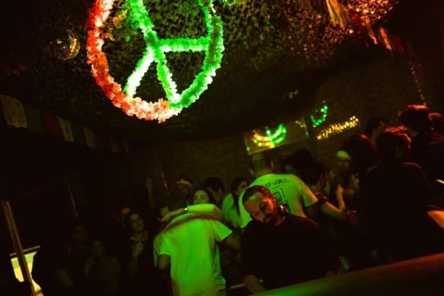 Dancers under green-lit décor at The Loft by Sporting, Sporting Club Beach