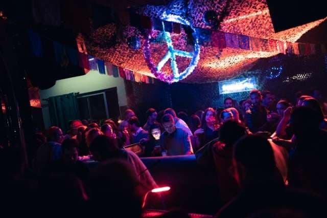 A night crowd lit in blue and red at The Loft by Sporting, Sporting Club Beach