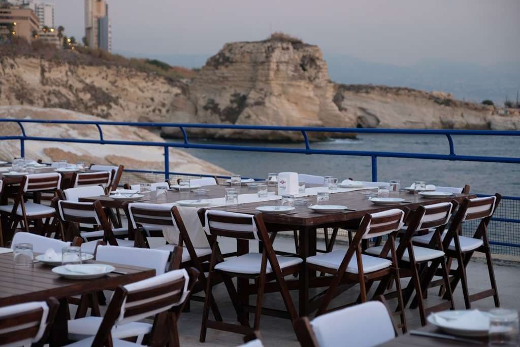 A waterfront table set with the rocky coast behind at Sporting Club Beach in Ras Beirut