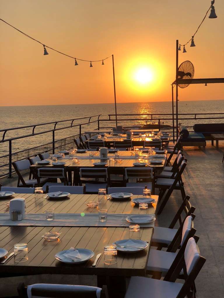 A sunset view across set tables to the sea from the terrace at Sporting Club Beach, Ras Beirut