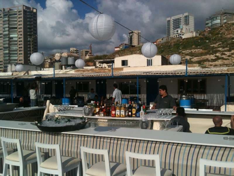 A terrace bar with paper lanterns and bottles set up for an event at Sporting Club Beach, Ras Beirut