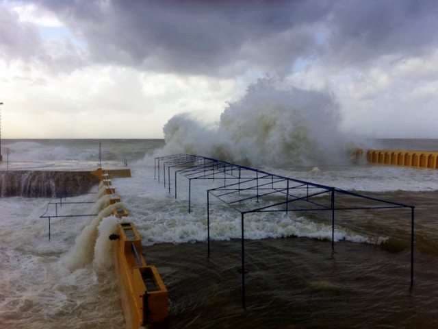 Storm waves surging over the seafront deck framing at Sporting Club Beach, Ras Beirut