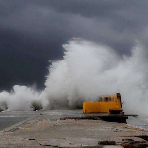 A large wave breaking over the seafront deck at Sporting Club Beach, Ras Beirut