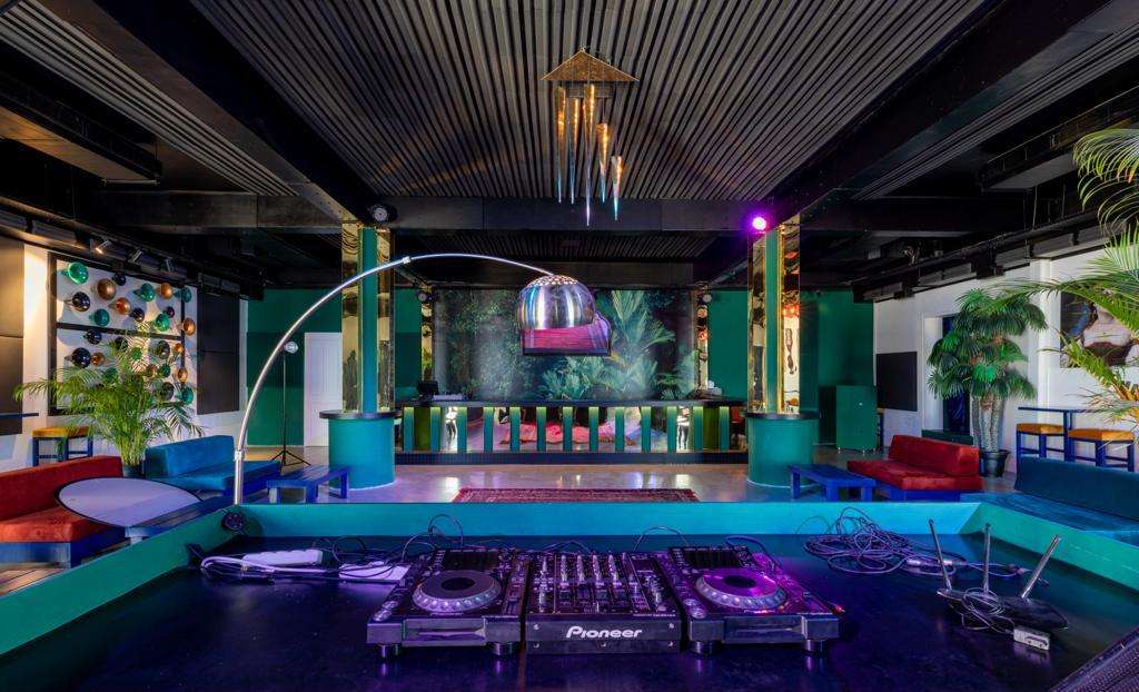 The Loft with DJ decks, mirrored columns and a red rug at Sporting Club Beach, Ras Beirut