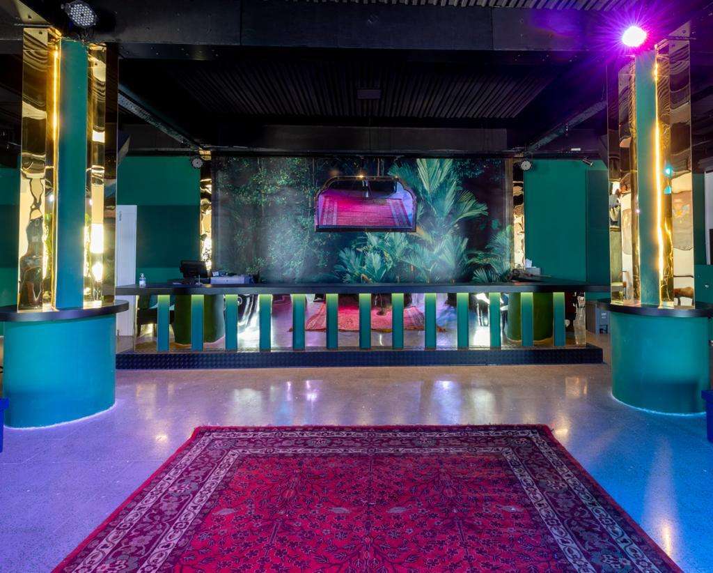 The Loft indoor bar and lounge with mirrored columns and a central red rug at Sporting Club Beach, Ras Beirut