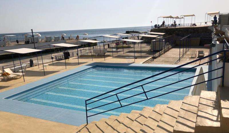 A saltwater pool with shaded poolside terraces overlooking the sea at Sporting Club Beach, Ras Beirut