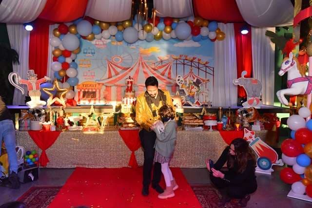 A family in front of the circus-themed dessert stage inside The Loft at Sporting Club Beach