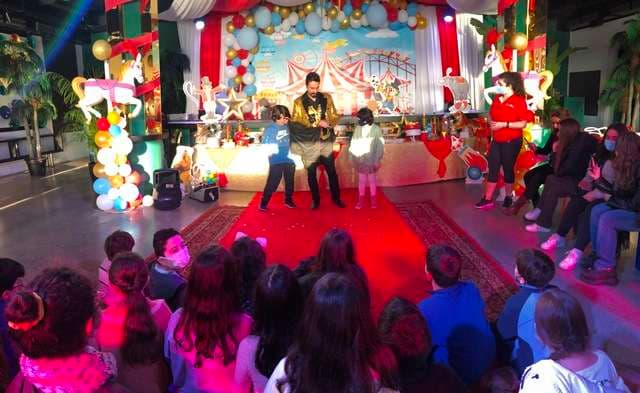 A children's party with a performer on stage at The Loft at Sporting Club Beach
