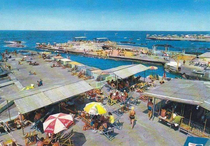 Sunbathers, cabanas and the seawater pool seen from above at Sporting Club Beach — an archive photograph