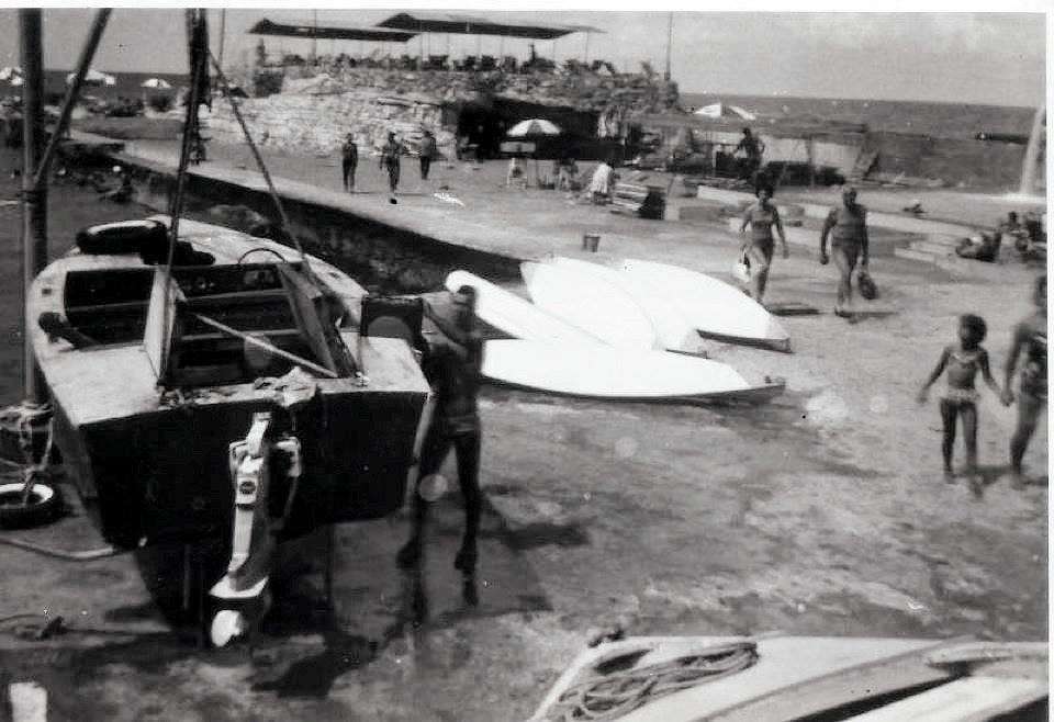 Boats, sailing dinghies and swimmers along the shore at Sporting Club Beach — an archive photograph