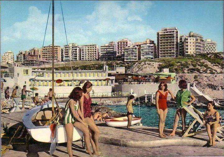 Members and sailing boats on the deck with the Beirut skyline behind at Sporting Club Beach — an archive photograph