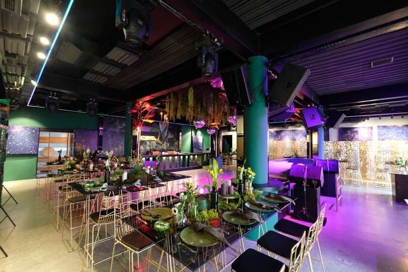 Event tables under coloured lighting in The Loft at Sporting Club Beach