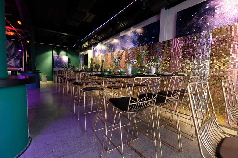 Bar stools and tables along a sequin wall in The Loft at Sporting Club Beach