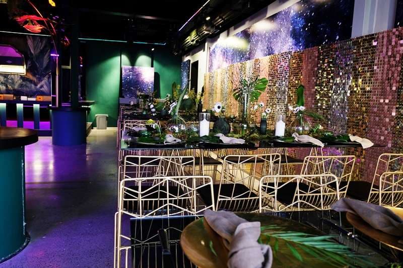 A long set table beside the sequin wall in The Loft at Sporting Club Beach