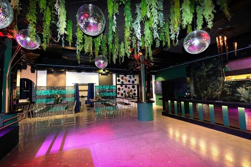 The Loft dancefloor with disco balls and hanging greenery at Sporting Club Beach