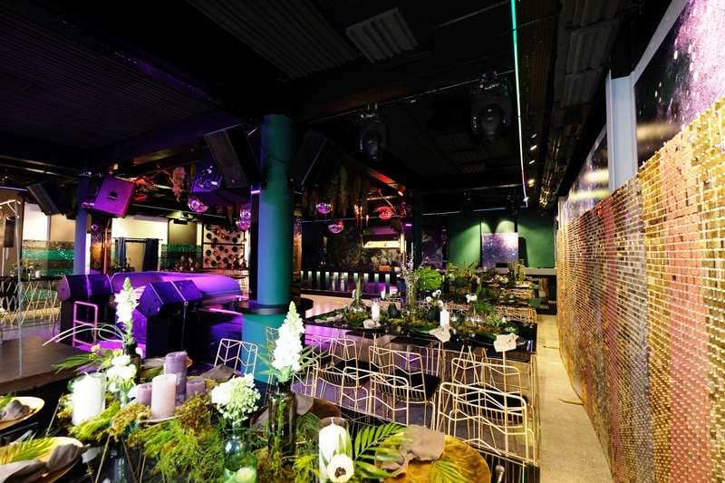 Event tables and lounge seating beside the sequin wall in The Loft at Sporting Club Beach
