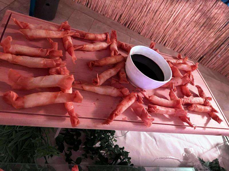 Fried rolls arranged around a bowl of dipping sauce at Sporting Club Beach