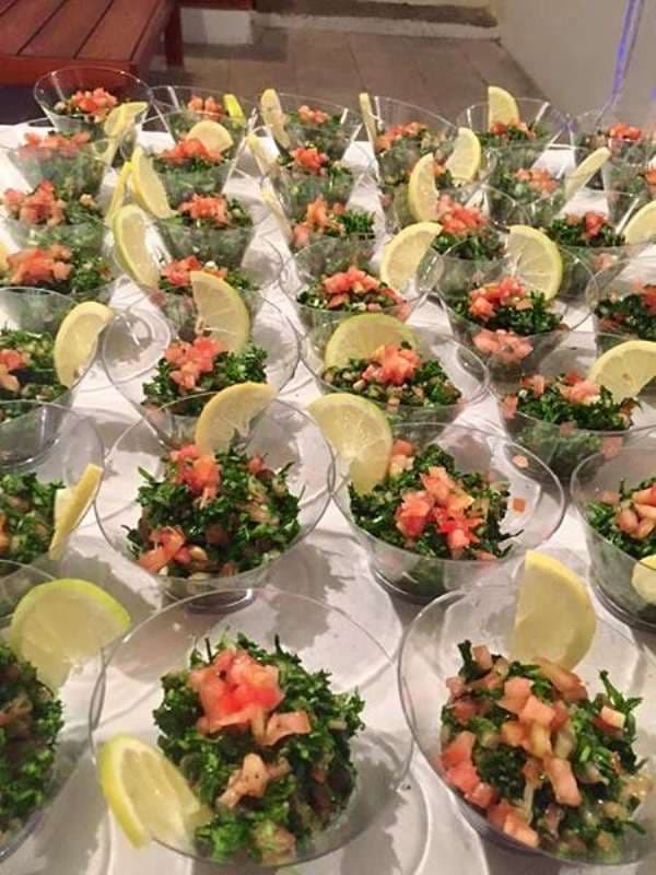 Tabbouleh in clear cocktail cups with lemon wedges at Sporting Club Beach