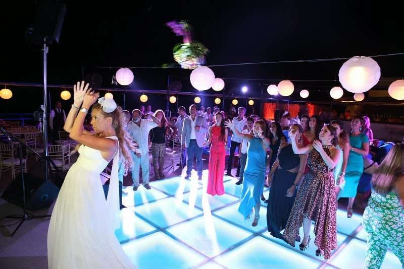An outdoor party on a lantern-lit deck at night at Sporting Club Beach