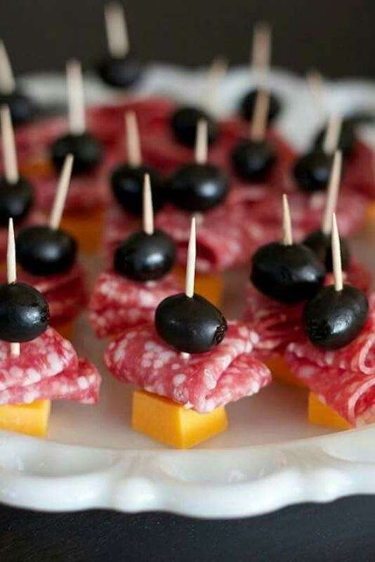 Salami, cheese and olive bites on cocktail picks on a plate at Sporting Club Beach