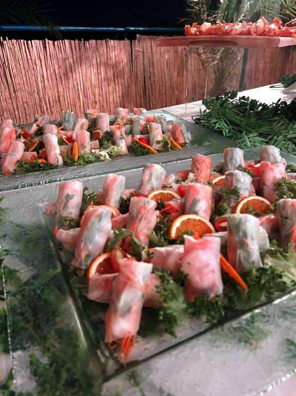 Rice-paper rolls with shrimp and orange slices on glass platters at Sporting Club Beach