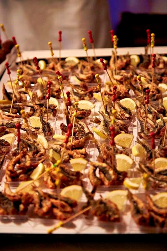 A tray of fried small fish on cocktail picks with lemon at Sporting Club Beach