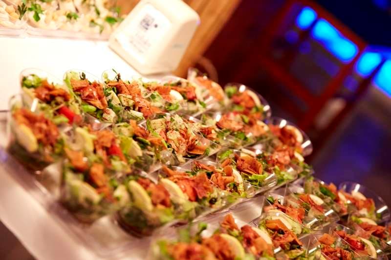 Individual salad cups with greens and a crisped topping at Sporting Club Beach