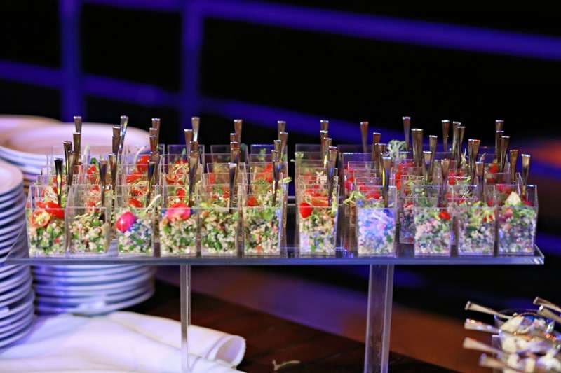 Rows of clear party cups of salad bites at Sporting Club Beach