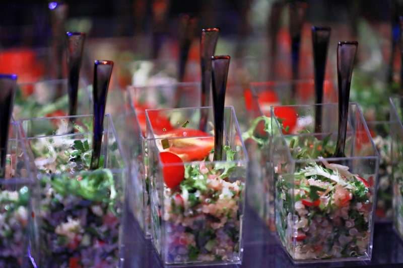 Tabbouleh-style salad portioned in clear cups with spoons at Sporting Club Beach