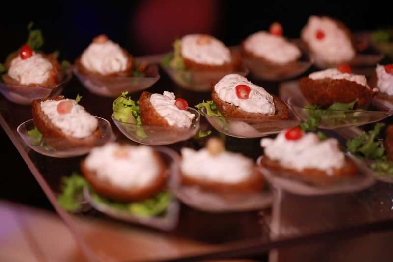 Toast canapés topped with spread and pomegranate seeds at Sporting Club Beach