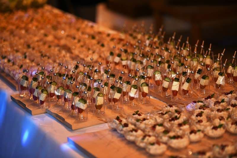 Canapés arranged in rows on a buffet at an indoor event at Sporting Club Beach