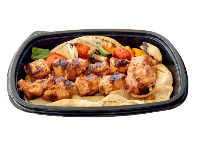 Grilled shish taouk skewers with vegetables and flatbread at Sporting Club Beach