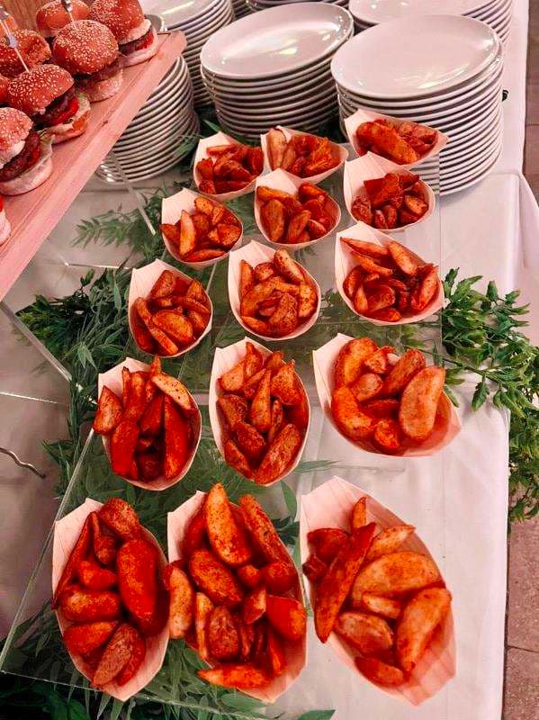 A buffet spread of seasoned potato wedges and sliders at Sporting Club Beach